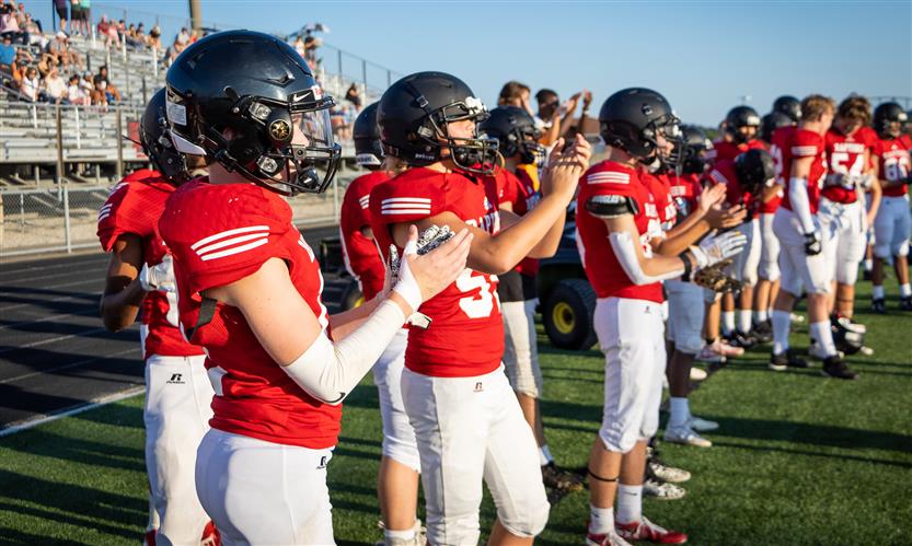 Football players stand on the sidelines
